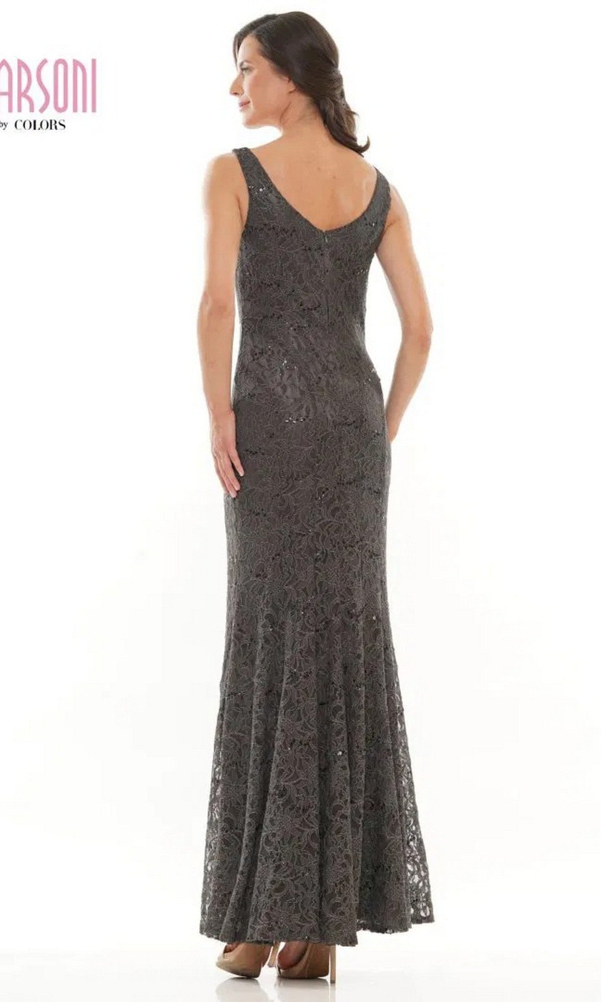 A woman models the Marsoni M301 long formal dress, standing with her back to the camera to reveal the intricate sleeveless lace design against a plain white background.